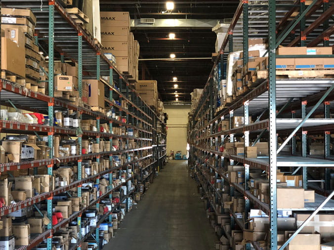 Warehouse shelves stocked with plumbing supplies at Hughes Supply Denver CO